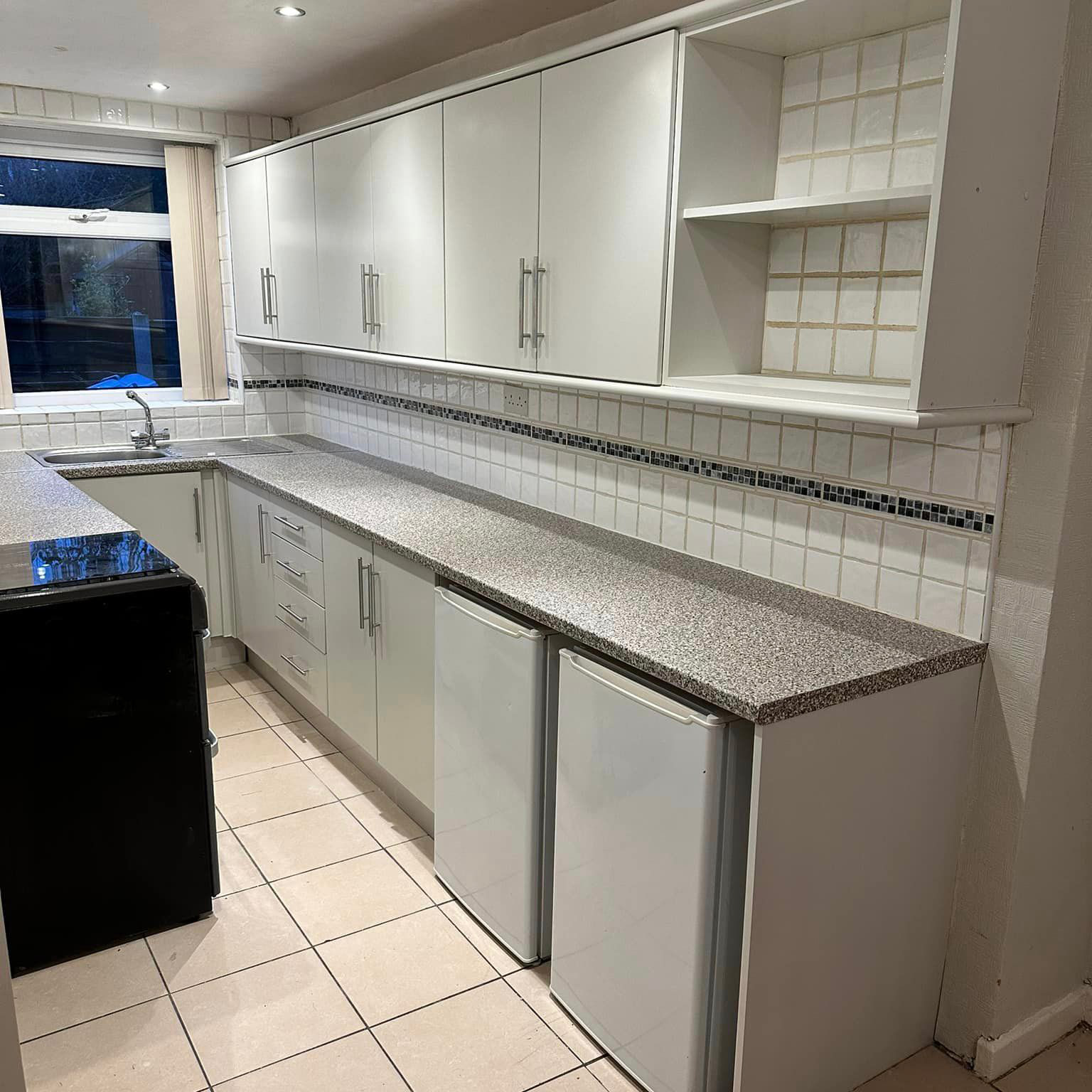 Small kitchen with white sprayed cupboards